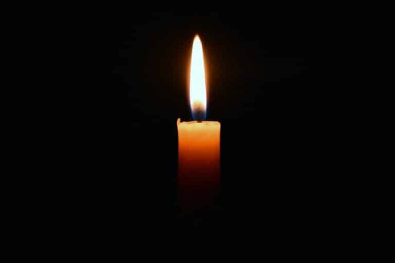a lit candle in the dark