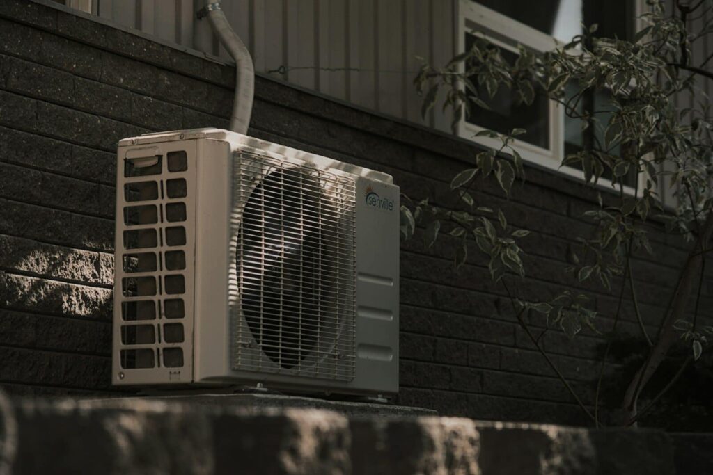 a white air conditioner sitting on top of a brick wall